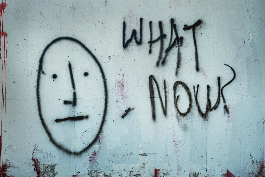 "what now?" written on a white wall